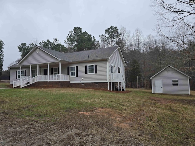 view of front of house with a front lawn, an outbuilding, covered porch, and crawl space