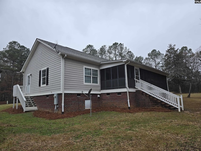 view of front of house featuring a sunroom, stairs, and a front lawn