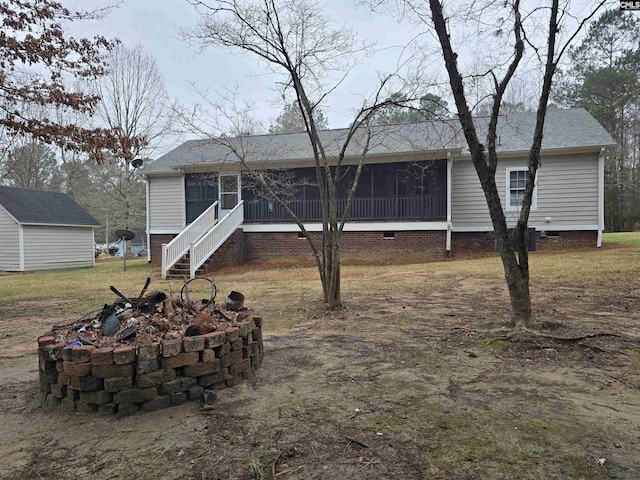 back of house featuring crawl space, a sunroom, and stairs