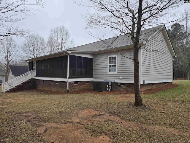 rear view of house featuring central air condition unit, a sunroom, a yard, stairway, and crawl space