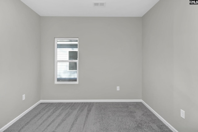 carpeted spare room with baseboards and visible vents