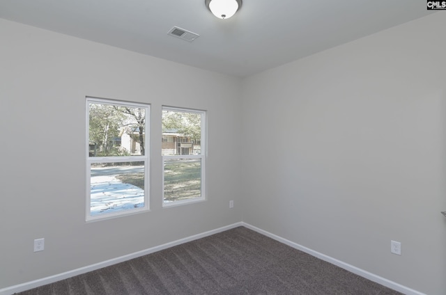 carpeted empty room with visible vents and baseboards