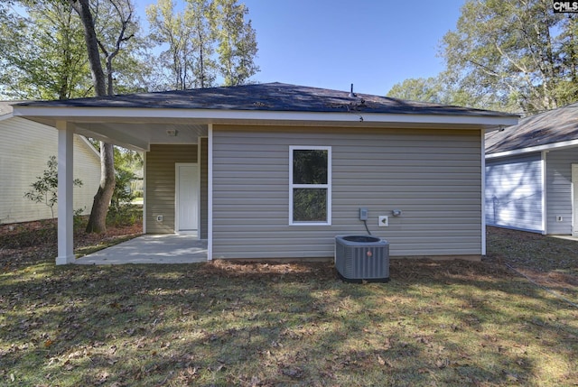 rear view of property featuring a yard, a patio, and central air condition unit