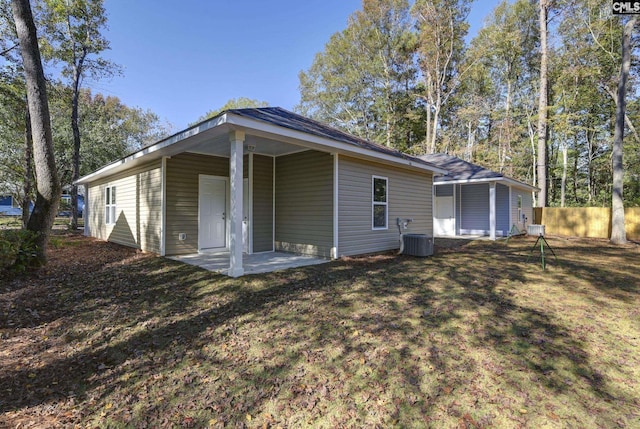 back of property with a yard, fence, central AC, and a patio