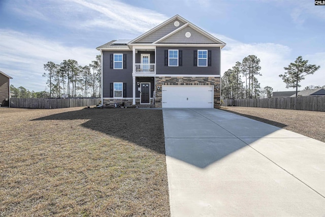 craftsman-style home featuring driveway, stone siding, fence, and roof mounted solar panels