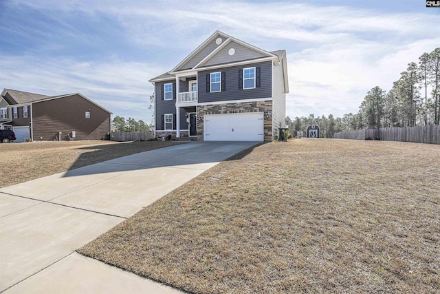 view of front of home featuring driveway, a garage, stone siding, fence, and a front lawn