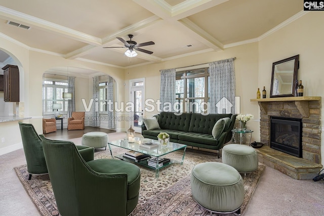 living area with arched walkways, visible vents, beamed ceiling, and a fireplace