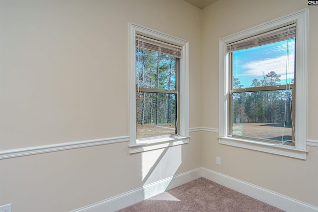 unfurnished room with light carpet and baseboards