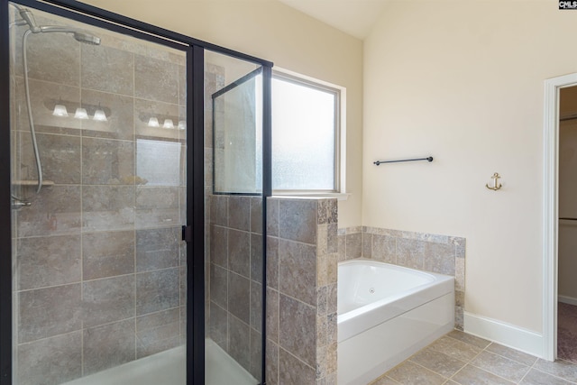 full bathroom with a stall shower, tile patterned flooring, baseboards, and a bath