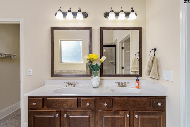 bathroom with a sink, a shower stall, and double vanity