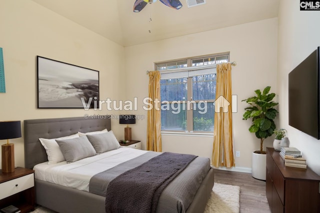 bedroom with visible vents, vaulted ceiling, and wood finished floors