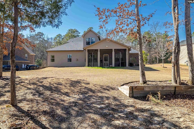 rear view of property featuring a sunroom and a lawn