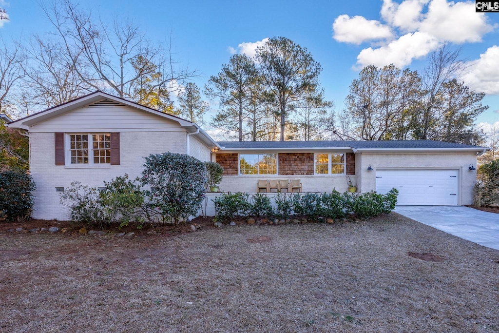 view of front of property featuring a garage, concrete driveway, and brick siding