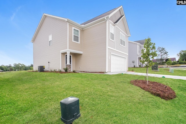 view of front of home featuring an attached garage, driveway, a front lawn, and central AC