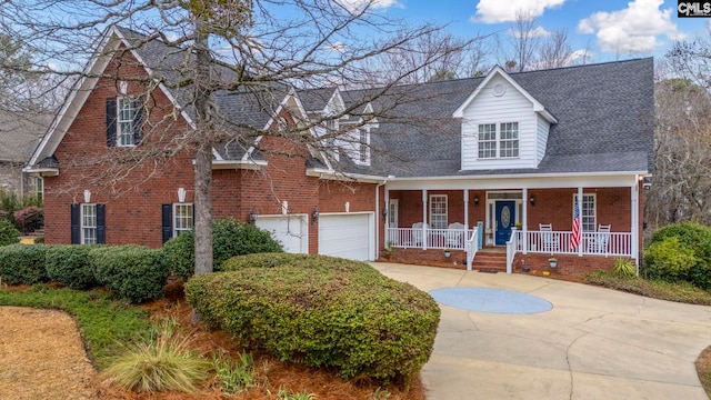 view of front facade with driveway, covered porch, a garage, and brick siding