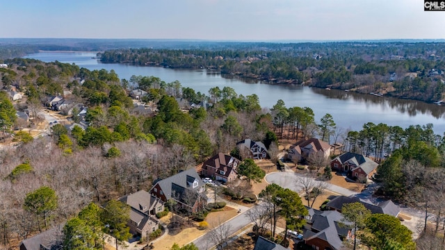 drone / aerial view with a water view, a residential view, and a view of trees