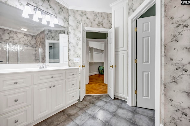 bathroom with wallpapered walls, vanity, ornamental molding, and a stall shower