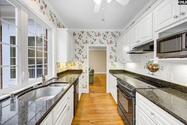 kitchen featuring wallpapered walls, under cabinet range hood, black appliances, white cabinetry, and a sink