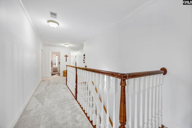 hallway featuring baseboards, ornamental molding, visible vents, and light colored carpet