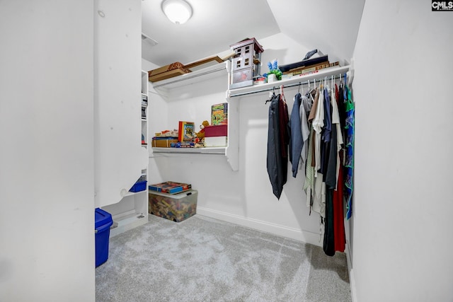 spacious closet with light carpet and vaulted ceiling