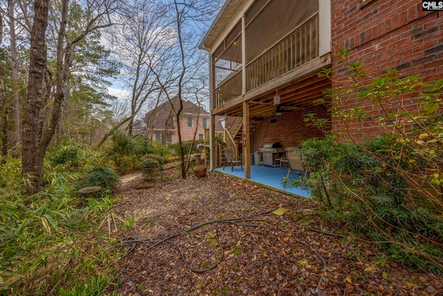 view of yard featuring a sunroom, a patio area, and stairway