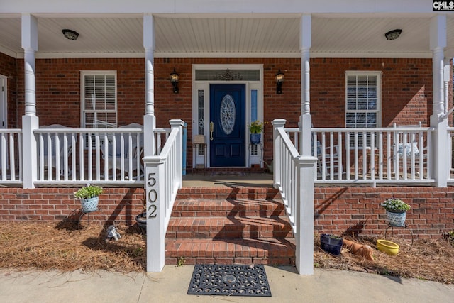 doorway to property featuring brick siding