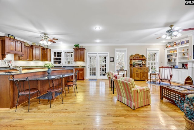 kitchen with light wood-style floors, a breakfast bar area, and ornamental molding