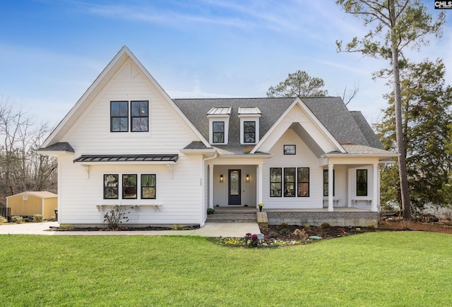 modern farmhouse style home with a front yard, covered porch, and a standing seam roof