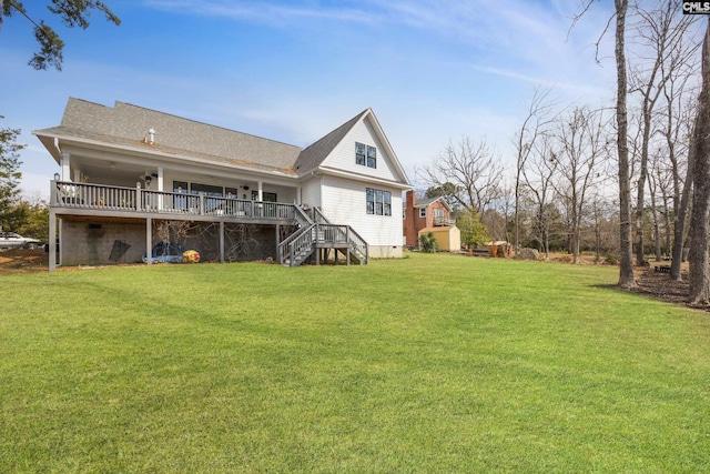 back of house featuring a shingled roof, a yard, a deck, and stairs