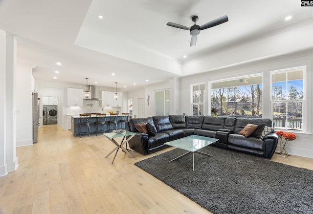 living room featuring light wood-style floors, recessed lighting, washer and clothes dryer, and baseboards