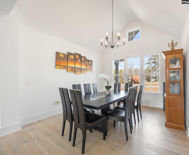 dining space with light wood-type flooring, a wealth of natural light, a notable chandelier, and baseboards