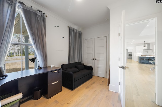 office area featuring washer / dryer, light wood-style flooring, and ornamental molding