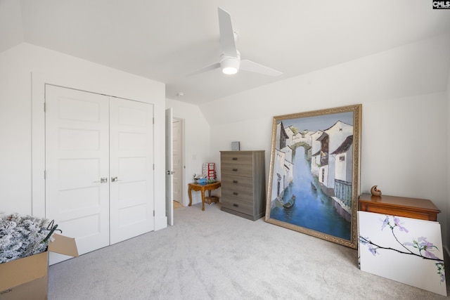 bedroom featuring lofted ceiling, ceiling fan, a closet, and light colored carpet