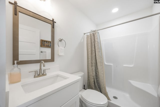 bathroom with toilet, a stall shower, and vanity