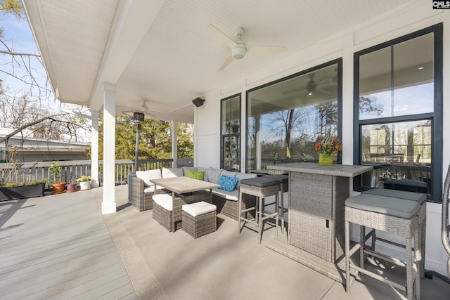 view of patio / terrace with ceiling fan, an outdoor bar, a wooden deck, and an outdoor living space