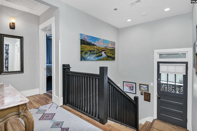 entrance foyer featuring baseboards, visible vents, and wood finished floors