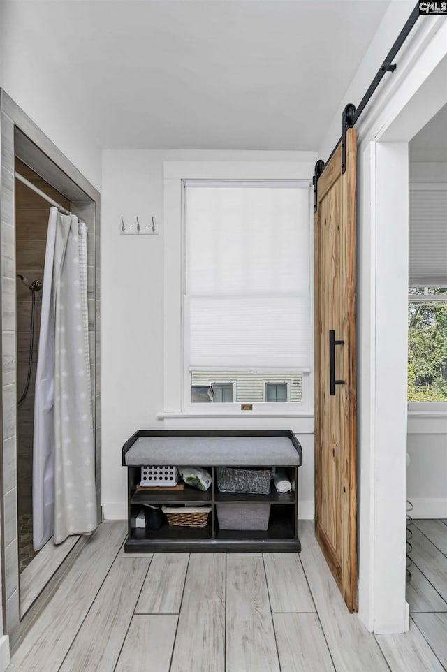 full bathroom with baseboards, a shower with shower curtain, and wood tiled floor