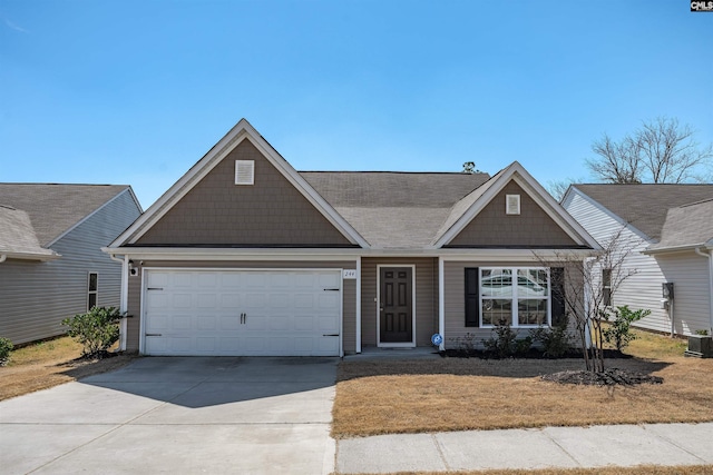 view of front facade with driveway, an attached garage, and central air condition unit