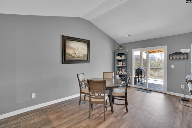 dining space with baseboards, visible vents, vaulted ceiling, and dark wood-type flooring