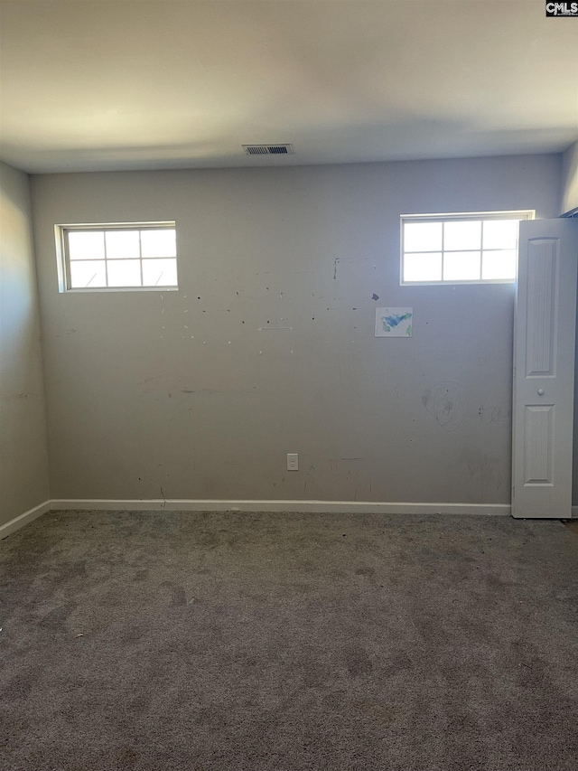 unfurnished room featuring carpet, visible vents, and baseboards