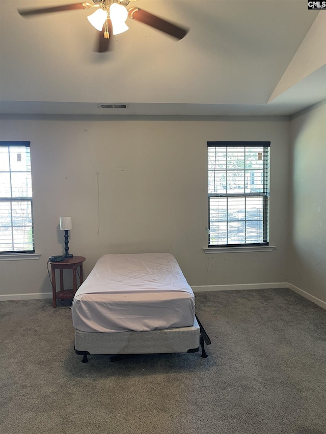 carpeted bedroom featuring lofted ceiling, ceiling fan, visible vents, and baseboards