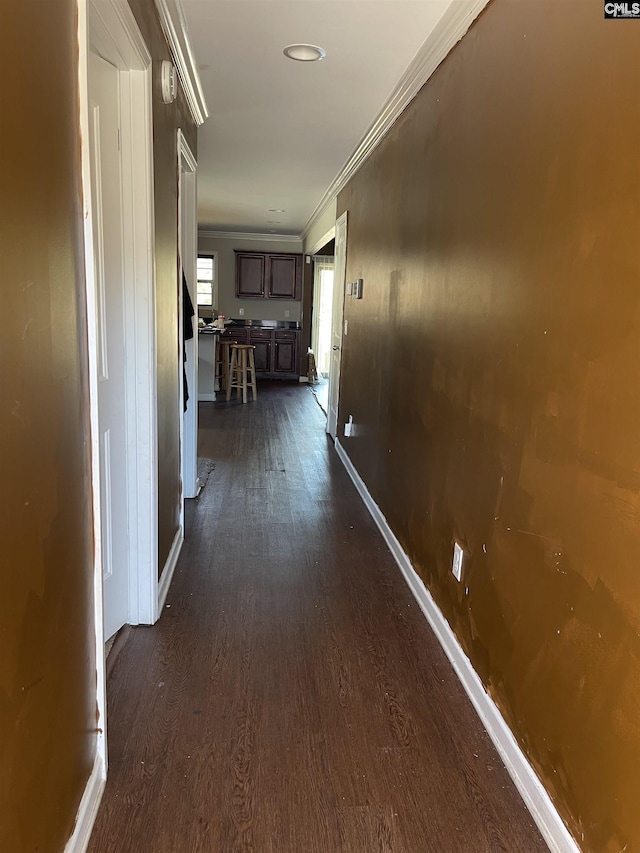 hallway with baseboards, dark wood finished floors, and crown molding