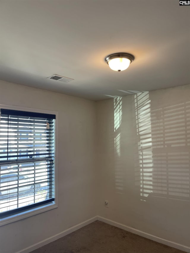 empty room with carpet, baseboards, and visible vents