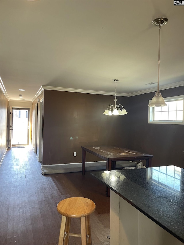 interior space featuring an inviting chandelier, baseboards, dark wood finished floors, and crown molding