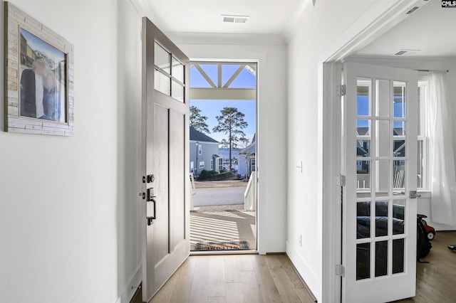 foyer with wood finished floors, visible vents, and baseboards