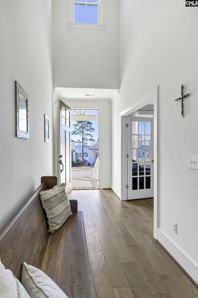 entrance foyer featuring hardwood / wood-style floors, a high ceiling, and baseboards