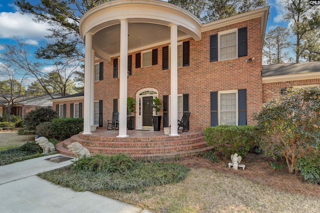 view of front facade with brick siding and a porch