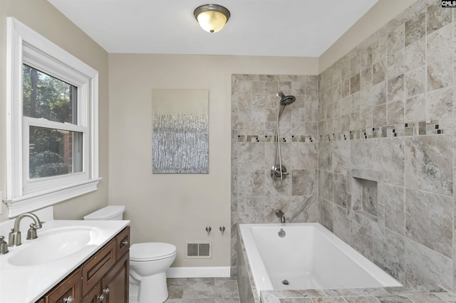 bathroom featuring visible vents, toilet, tiled shower / bath combo, vanity, and baseboards