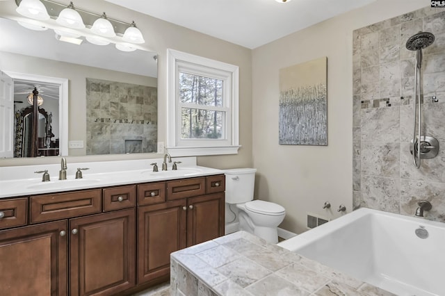 bathroom featuring double vanity, a sink, and toilet