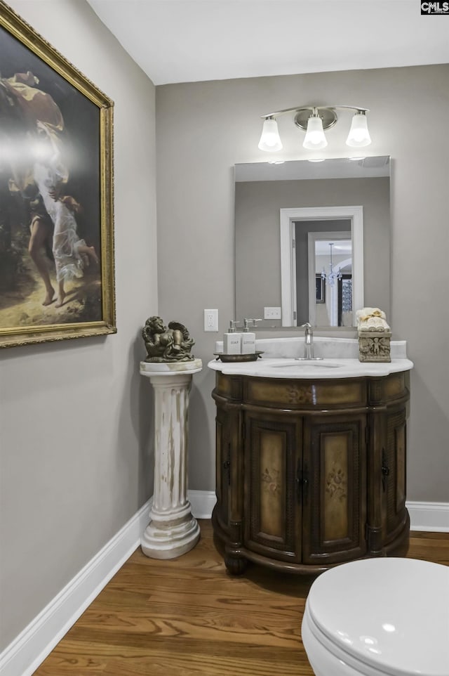 bathroom with vanity, baseboards, and wood finished floors